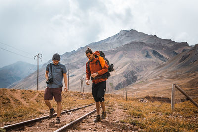 People standing on mountain road against sky