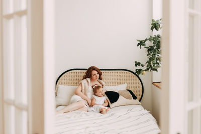 Happy mom and little daughter baby relax unwind and play in a cozy room in a cozy house