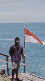 Full length of woman standing at sea against sky