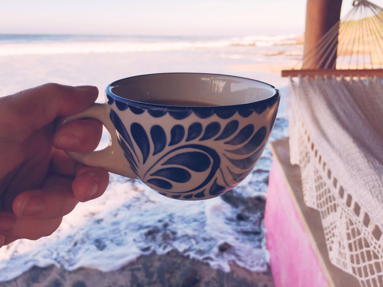 sea, part of, beach, lifestyles, leisure activity, close-up, holding, person, unrecognizable person, sky, water, focus on foreground, personal perspective, cropped, refreshment, drink