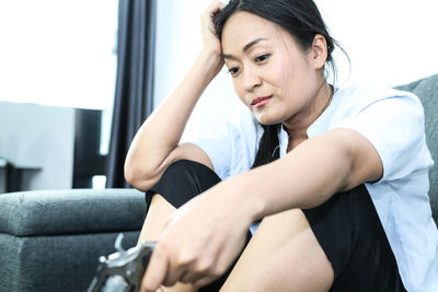 Young woman sitting on sofa at home