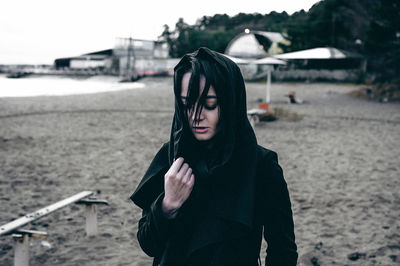 Young woman standing on sand at beach