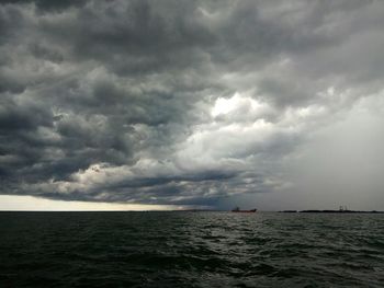 Scenic view of sea against storm clouds