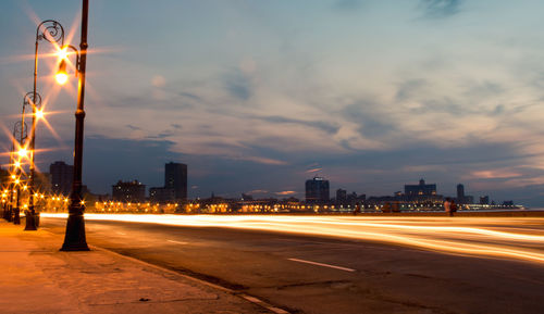 Light trails on road against sky during sunset