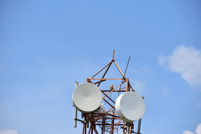 Low angle view of communications tower against blue sky