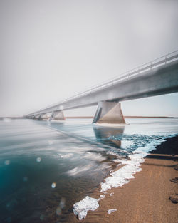 Bridge over sea against sky