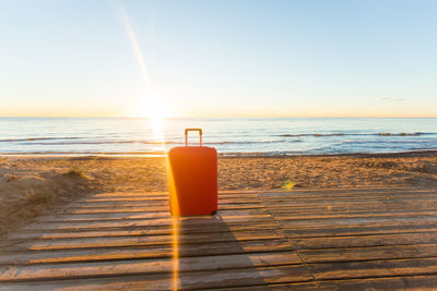 Water bottle on beach against sky during sunset