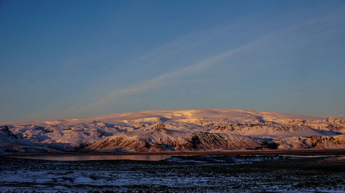 Scenic view of snowcapped mountains against sky during sunset