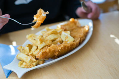 Close-up of hand holding food in plate