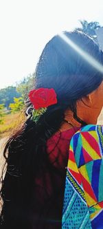 Rear view of woman with multi colored umbrellas against sky