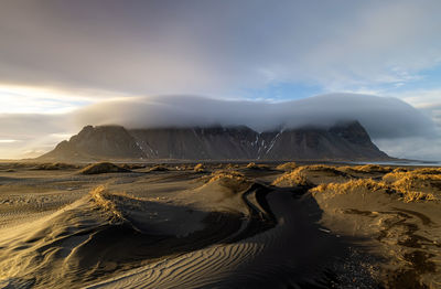 Scenic view of snowcapped mountains against sky at sunset 