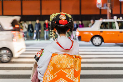 Rear view of woman standing on road