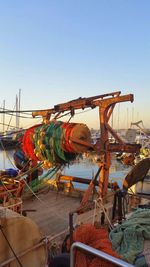 Boats moored at harbor against clear sky