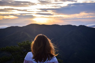 Rear view of woman looking at sunset