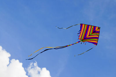 Low angle view of kite flying against blue sky