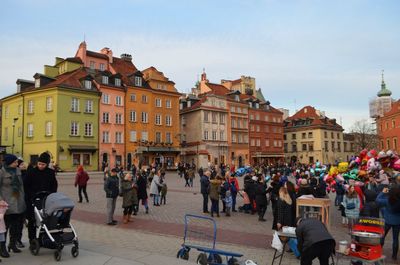 People on street against buildings in city