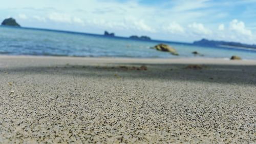 Surface level of calm beach against the sky