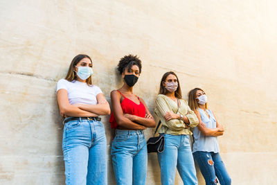 Women wearing face protective mask to avoid corona virus spread - young millennial women portrait 