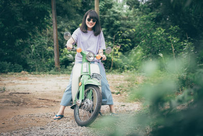 Full length of woman riding bicycle on street