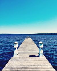 Pier over sea against blue sky