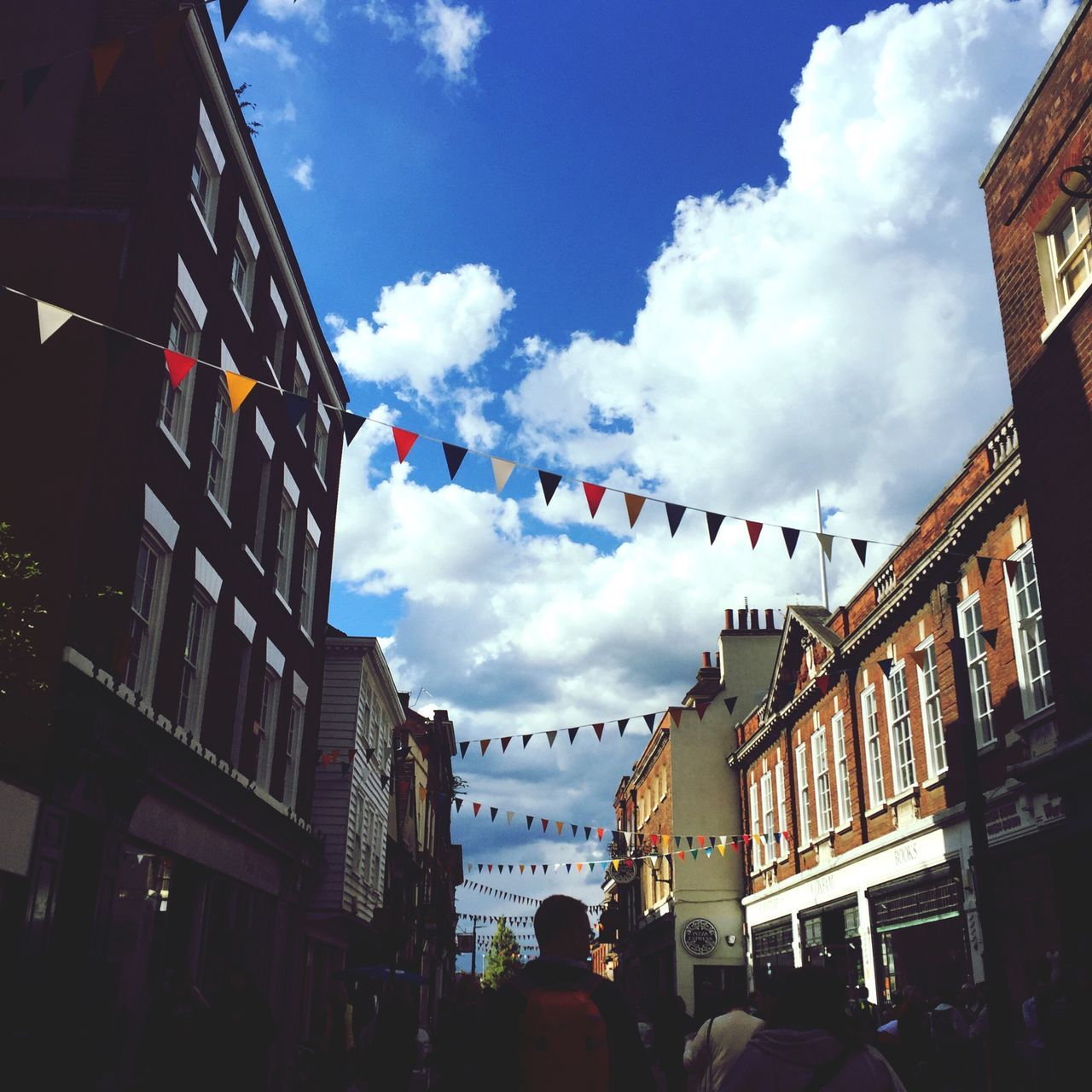 sky, cloud - sky, hanging, architecture, built structure, building exterior, large group of people, flag, low angle view, women, city, day, outdoors, people