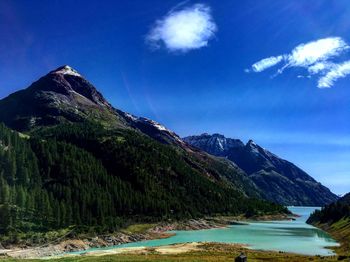 Scenic view of sea and mountains against blue sky