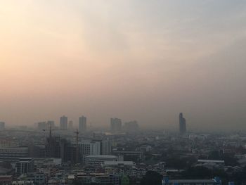 High angle view of modern buildings in city against sky during sunrise