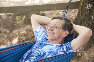 Portrait of young man sitting on hammock