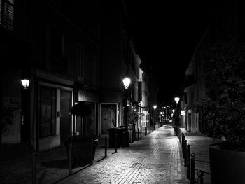 Empty alley along street at night