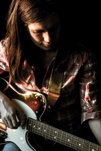 Young woman playing electric guitar