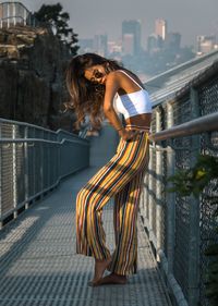 Woman standing by railing in city