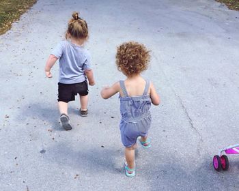 Rear view of siblings walking outdoors