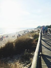 People walking on beach against sky