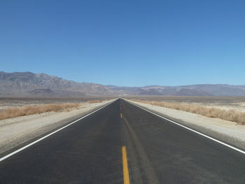 Empty road along countryside landscape