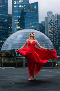 Portrait of smiling young woman standing in city