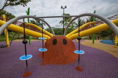Close-up of multi colored playground in park against sky