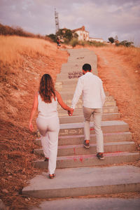 Full length of young couple on steps at sunset