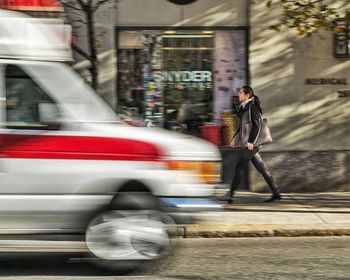 Blurred motion of people walking on city street