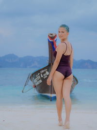 Full length of woman standing on beach against sky