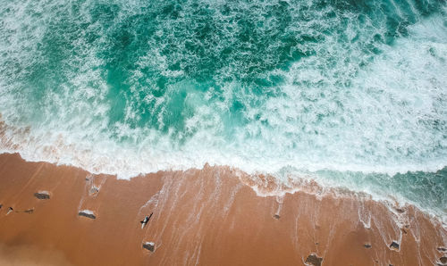 High angle view of waves splashing on beach