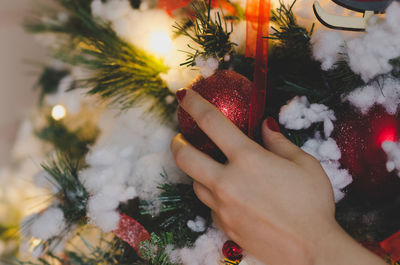 Close-up of hand touching christmas tree