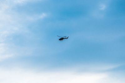 Low angle view of helicopter flying in sky