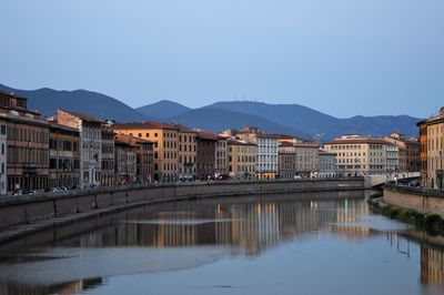 River by buildings in city against clear sky