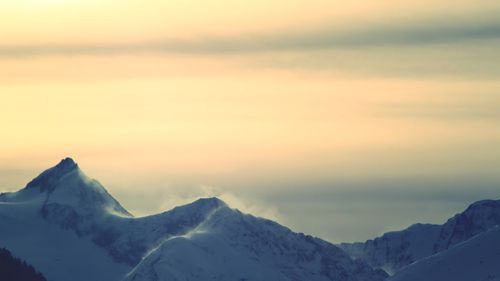 Scenic view of snowcapped mountains against sky during sunset