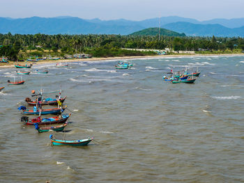 People in boat on river against mountains