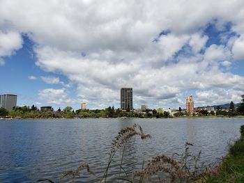 River by city buildings against sky