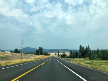 Road passing through landscape against sky