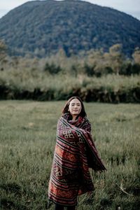 Portrait of a smiling young woman standing on field