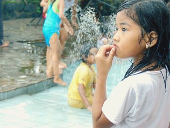 Thoughtful girl standing at swimming pool