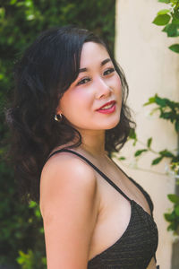 Portrait of asian woman wearing swimsuit in front of a flower bush